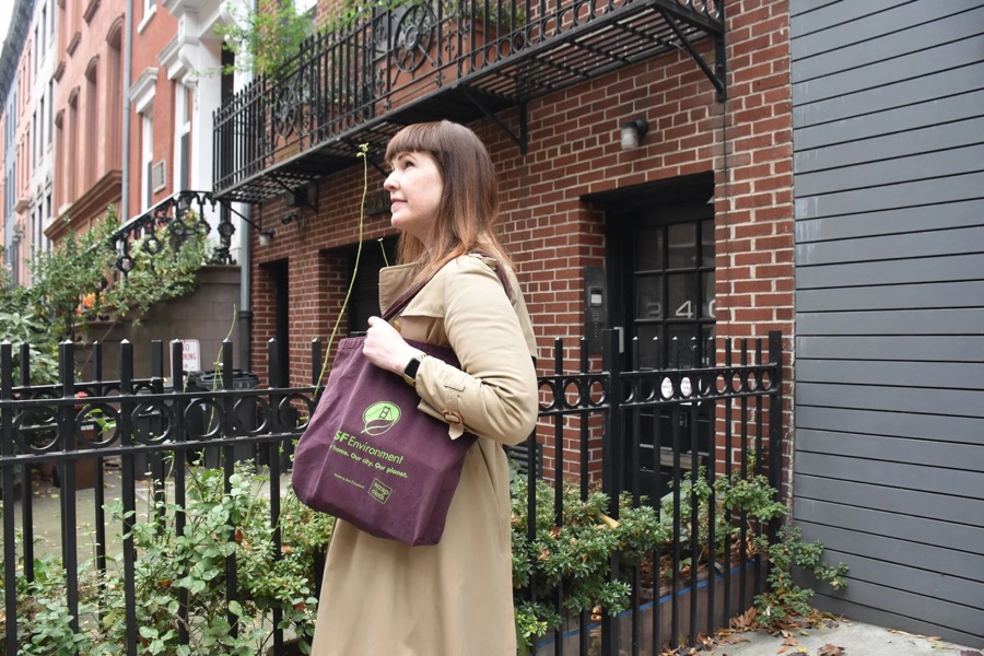 Jennie Romer on a New York City sidewalk carrying a reusable tote bag